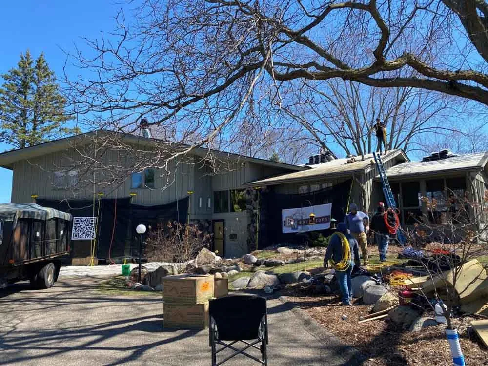 BN Exteriors crew working on a Minnesota home with the company banner across the front