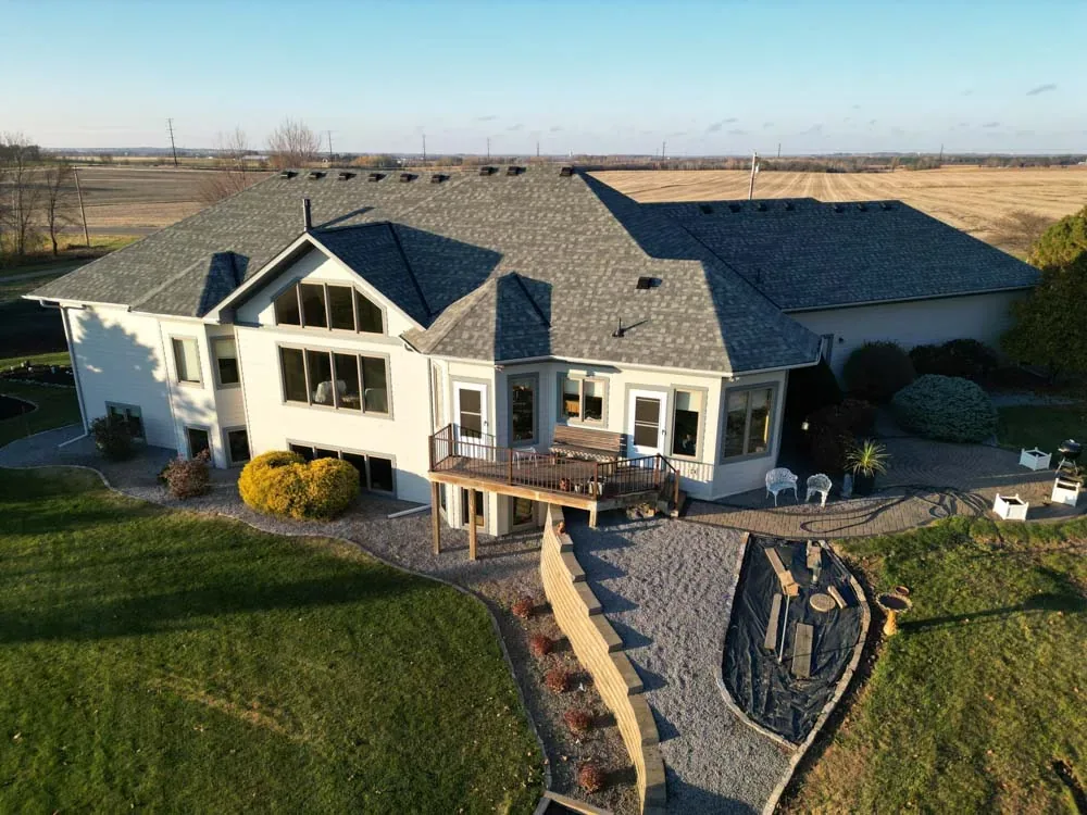 Aerial view of a large home and outbuildings with new roofing