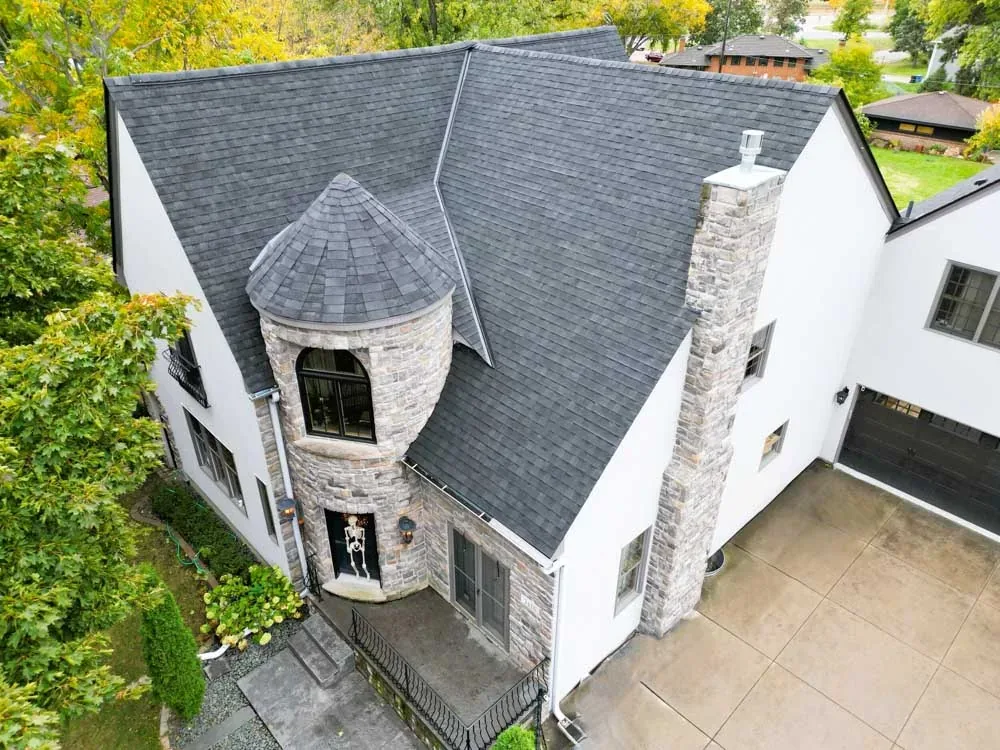 Aerial view of a white modern home with a new dark roof