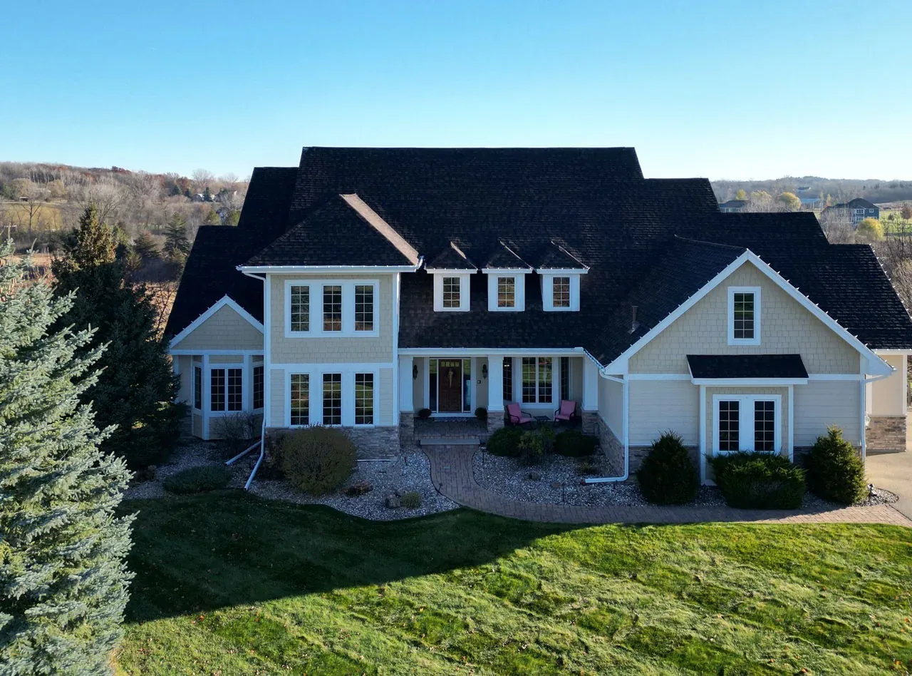 Aerial view of a large home with a new dark shingle roof