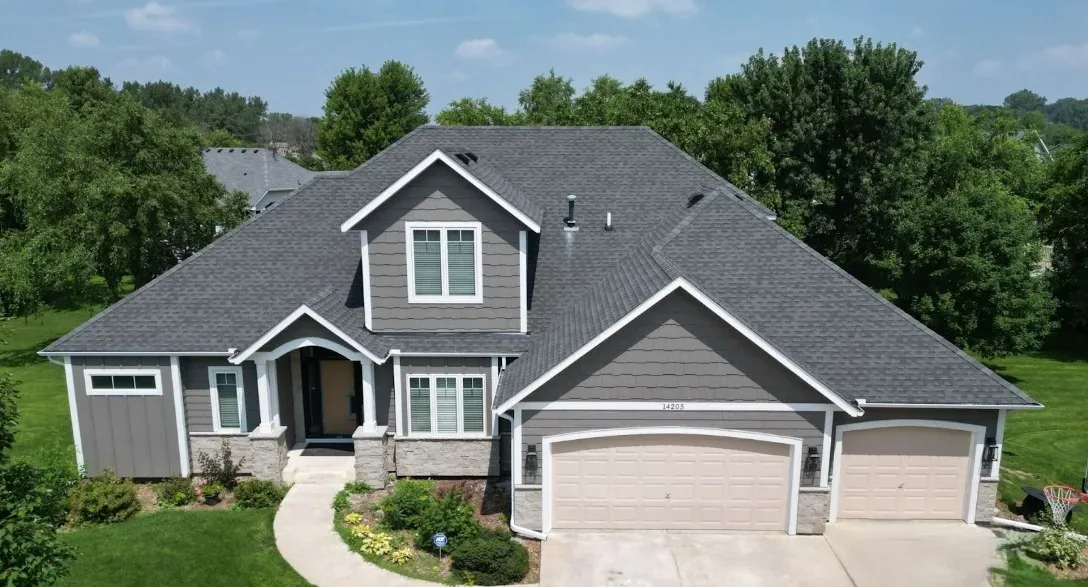 Aerial view of a home with new gray siding and white trim