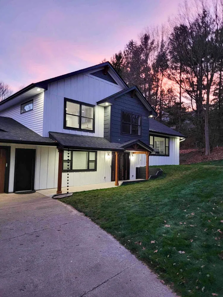 Modern home at dusk with large lit windows