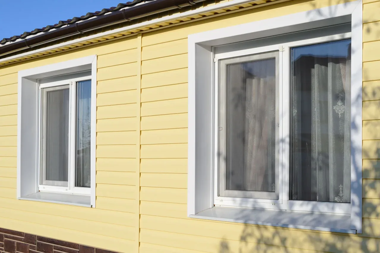 Yellow home with new white replacement windows