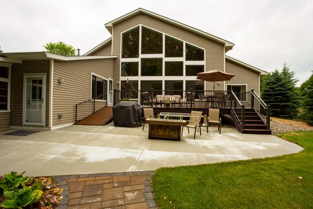 Rear of a home with large windows over a patio and deck